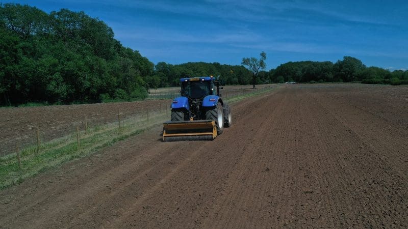 Blue tractor working on soil seeding
